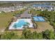 Aerial view of a community pool, clubhouse, playground and sports courts in a residential area at 512 Stowers Dr, New Smyrna Beach, FL 32168