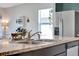 Modern kitchen featuring granite countertops, stainless steel appliances, and an open layout leading to the dining area at 512 Stowers Dr, New Smyrna Beach, FL 32168