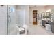 Bright bathroom with a glass-enclosed shower, double vanity, and a view into the walk-in closet at 5641 Nevis Ter, Kissimmee, FL 34758