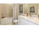 Well-lit bathroom featuring a vanity with a granite countertop, tiled walls, and a shower/tub combination at 5641 Nevis Ter, Kissimmee, FL 34758