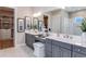 Bathroom with a double vanity, a large mirror, and an open entrance to the walk-in closet at 5641 Nevis Ter, Kissimmee, FL 34758