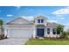 Beautiful, single-story home featuring a 2-car garage, blue front door, manicured lawn, and thoughtfully designed landscaping at 5641 Nevis Ter, Kissimmee, FL 34758