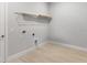 Well-lit laundry room with modern light-gray walls, bright-white trim, and convenient shelving at 5641 Nevis Ter, Kissimmee, FL 34758