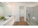 Bright bathroom featuring a double vanity, large mirror, and tiled walk-in shower at 5647 Nevis Ter, Kissimmee, FL 34758