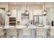 Well-lit kitchen featuring a large island with bar stools, stainless steel appliances, and modern pendant lights at 5647 Nevis Ter, Kissimmee, FL 34758