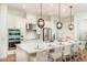 Bright kitchen with white cabinets, stainless steel appliances, large island and pendant lighting at 5647 Nevis Ter, Kissimmee, FL 34758