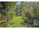 The spacious backyard has mature trees, colorful plants and green grass at 605 Sweetbriar Rd, Orlando, FL 32806