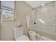 Bright bathroom features a toilet, bidet and a glass shower with white marble wall and tiled floor at 605 Sweetbriar Rd, Orlando, FL 32806