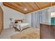 Bright bedroom with wood ceiling, ceiling fan, a bed with white bedding, and a tiled floor at 605 Sweetbriar Rd, Orlando, FL 32806