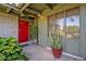 Close up of a well-lit red front door entrance with lush greenery and a modern address display at 605 Sweetbriar Rd, Orlando, FL 32806