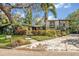 Two-story home featuring mature trees, colorful plants, and inviting walkway leading to the main entrance at 605 Sweetbriar Rd, Orlando, FL 32806