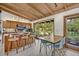 Modern kitchen with a breakfast bar, wood cabinets, and a view of the lush backyard at 605 Sweetbriar Rd, Orlando, FL 32806