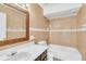 Well-lit bathroom with tiled walls, white toilet, bathtub, and vanity with sink and mirror at 626 Golden Sunshine Cir, Orlando, FL 32807
