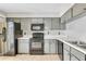 Galley kitchen with stainless steel appliances, gray cabinets, and black countertops at 626 Golden Sunshine Cir, Orlando, FL 32807
