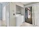Functional laundry area equipped with a washer, dryer, shelving, and sliding glass doors to the outside at 626 Golden Sunshine Cir, Orlando, FL 32807