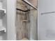 Tiled shower with glass doors and shelving at 649 Caribou Ct, Poinciana, FL 34759