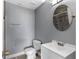 Bathroom with gray walls featuring a sink, toilet and a shower with glass doors at 649 Caribou Ct, Poinciana, FL 34759