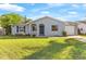 Charming single-story home with a well-manicured lawn and gray exterior paint at 649 Caribou Ct, Poinciana, FL 34759