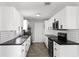Modern kitchen featuring stainless steel appliances, subway tile backsplash, and black countertops at 649 Caribou Ct, Poinciana, FL 34759