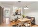 Bright dining area features hardwood flooring, light-colored wood table with four chairs and kitchen access at 660 Celebration Ave # 220, Celebration, FL 34747