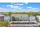 Three-story condo building with central parking, lush landscaping, and partial cloudy sky at 660 Celebration Ave # 220, Celebration, FL 34747
