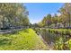 Scenic street view along waterway featuring lush lawns, sidewalks, mature trees, and charming homes in the distance at 660 Celebration Ave # 220, Celebration, FL 34747