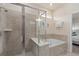 A modern bathroom featuring a separate glass-enclosed shower and a relaxing soaking tub, designed for comfort and elegance at 7180 Oakmoss Loop, Davenport, FL 33837