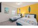 Bright bedroom with two twin beds, surfboard decor, and colorful accents, perfect for a fun and inviting space at 7180 Oakmoss Loop, Davenport, FL 33837