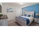 Charming bedroom featuring beach-themed decor, a soothing blue accent wall, and a comfortable, stylish bed at 7180 Oakmoss Loop, Davenport, FL 33837