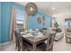Stylish dining room with a blue accent wall, modern lighting, and a view into the living room at 7180 Oakmoss Loop, Davenport, FL 33837