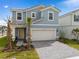 Charming two-story home featuring a two-car garage, well-manicured landscaping, and a welcoming entrance at 7180 Oakmoss Loop, Davenport, FL 33837