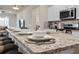 Kitchen island featuring granite countertops, bar stool seating, stainless steel appliances and modern finishes at 7180 Oakmoss Loop, Davenport, FL 33837