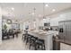 Spacious kitchen with granite countertops, stainless steel appliances, and an adjacent dining and living area at 7180 Oakmoss Loop, Davenport, FL 33837