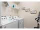 Functional laundry room equipped with a washer, dryer, and shelving, offering convenience and organization at 7180 Oakmoss Loop, Davenport, FL 33837