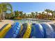 Relaxing lazy river with colorful inner tubes, palm trees, and sun loungers, perfect for leisure at 7180 Oakmoss Loop, Davenport, FL 33837