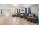 Expansive living room with wood flooring, large sectional sofa, and bright natural light offers space for relaxation at 7180 Oakmoss Loop, Davenport, FL 33837