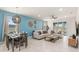Inviting living room with stylish decor, tile floors, a dining area, and sliding glass doors for indoor-outdoor living at 7180 Oakmoss Loop, Davenport, FL 33837