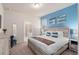 A serene main bedroom features a blue accent wall, beach-themed art, and an ensuite bathroom with a glass-enclosed shower at 7180 Oakmoss Loop, Davenport, FL 33837