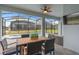 Covered patio with a dining table, chairs, ceiling fan, and mounted TV overlooking the pool and backyard at 7180 Oakmoss Loop, Davenport, FL 33837