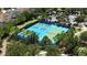 Community tennis courts with vibrant blue surfaces surrounded by mature trees and ample parking at 7180 Oakmoss Loop, Davenport, FL 33837