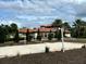 Outdoor sand volleyball court with well-maintained landscaping and community center in background at 7180 Oakmoss Loop, Davenport, FL 33837