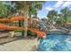 Inviting community pool with a fun water slide and lush tropical landscaping perfect for Gathering fun at 7180 Oakmoss Loop, Davenport, FL 33837