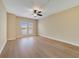 Bright bedroom featuring wood floors, neutral paint, ceiling fan, and a view from the windows at 7508 Toscana Blvd # 123, Orlando, FL 32819