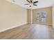 Bright bedroom featuring wood floors, neutral paint, ceiling fan, and view from the windows at 7508 Toscana Blvd # 123, Orlando, FL 32819