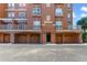 Ground-level condo garages with brick accents and tan roll-up doors in lower-angle shot at 7508 Toscana Blvd # 123, Orlando, FL 32819