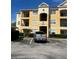 Exterior of building shows yellow stucco, black iron railings, and a gray pickup truck in the parking lot at 8124 Claire Ann Dr # 303, Orlando, FL 32825