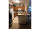 Compact kitchen with wood cabinets, white appliances, and a breakfast bar at 8124 Claire Ann Dr # 303, Orlando, FL 32825