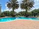 Beautiful community pool featuring dual palms, brick edging, and lounge chairs for a relaxing outdoor experience at 8124 Claire Ann Dr # 303, Orlando, FL 32825