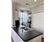 Cozy kitchen features a black countertop, stainless steel sink, and white cabinets at 860 N Orange Ave # 318, Orlando, FL 32801