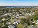 This aerial shot shows the established neighborhood, lush trees, a community pool, and views of the lake at 919 Timor Ave, Orlando, FL 32804